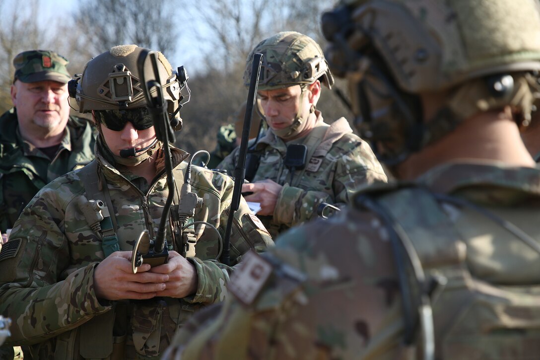 Soldiers look at radios.