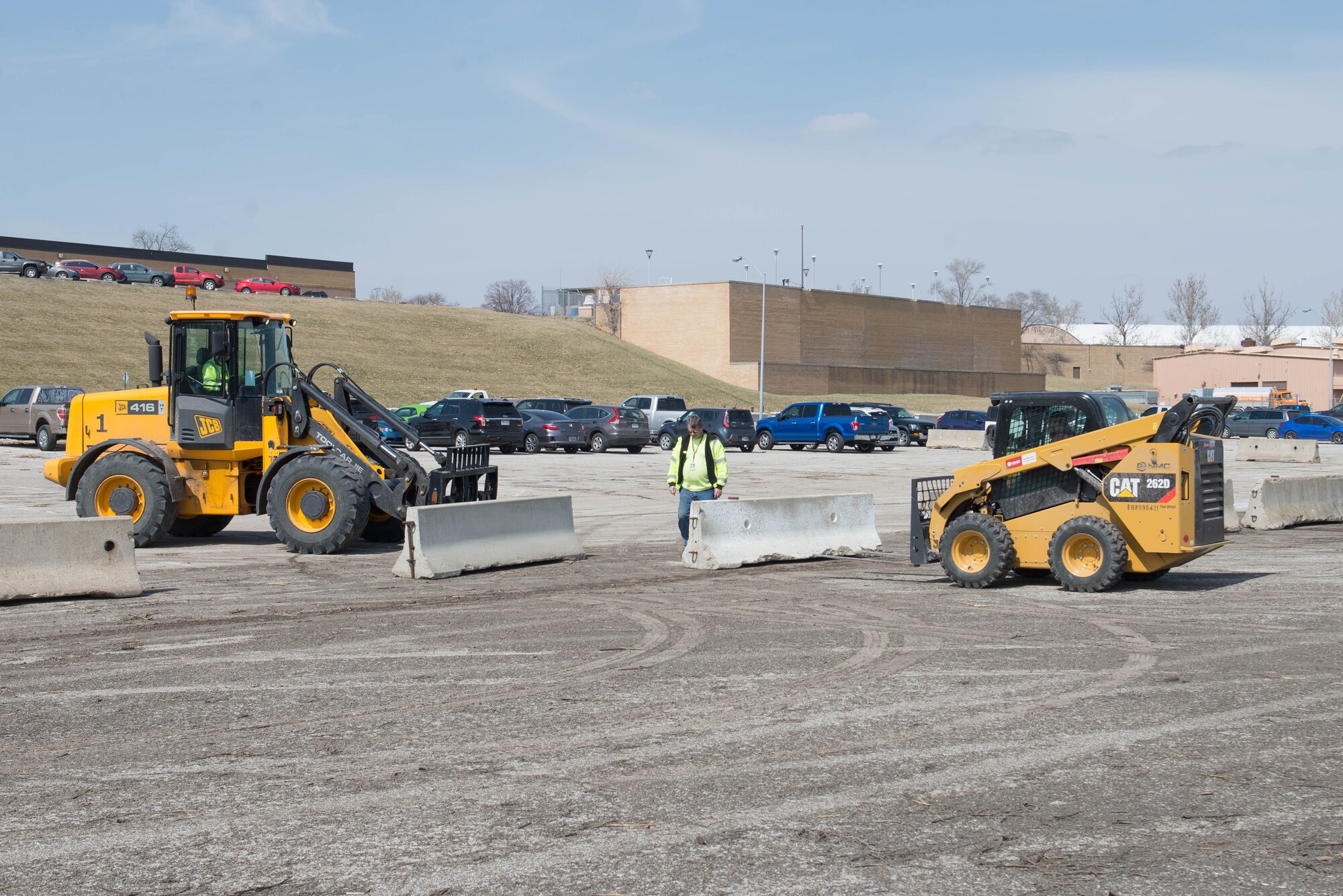 Members of the 55th Civil Engineer Squadron pavement and equipment team build the boundaries of a temporary parking lot exclusively for those who work in building 500 March 27, 2019, at Offutt Air Force Base, Nebraska. The temporary parking lot was established as part of the recovery from flooding on base that began March 15, 2019. (U.S. Air Force photo by Zachary Hada)