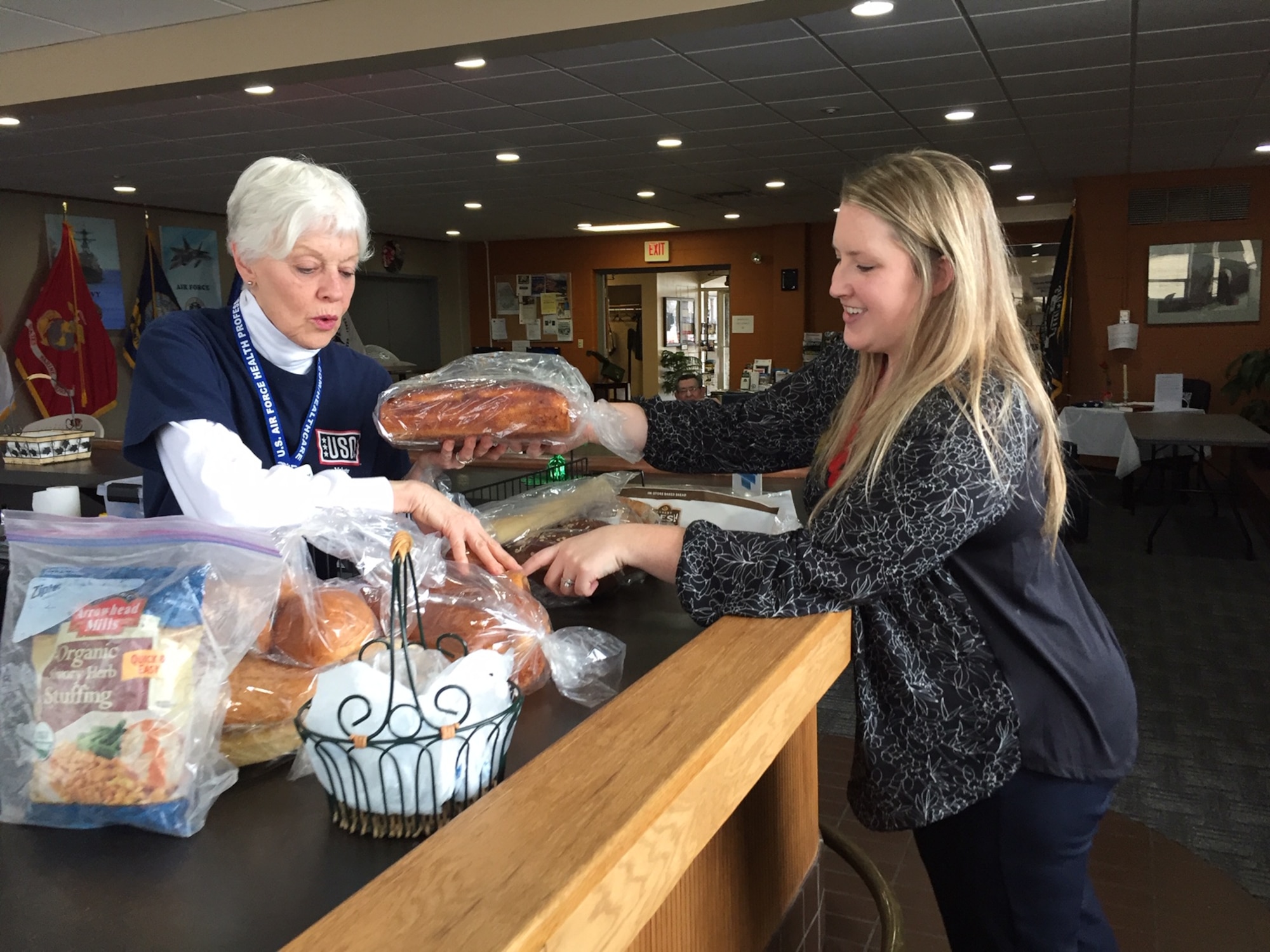Volunteer Tosca Hallock (left) and USO Center Manager Whitney Armstrong sort free bread for visitors inside Bldg. 1222, Kittyhawk Center, Area A, Wright-Patterson Air Force Base. (Skywrighter photo/Amy Rollins)
