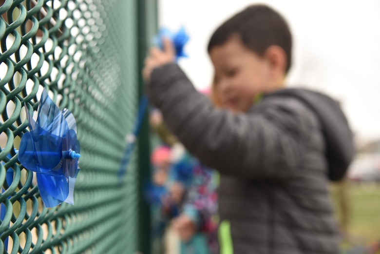 Children at the base child development center place pinwheels on a fence during Child Abuse Prevention Month April 11, 2019, at Malmstrom Air Force Base, Mont.