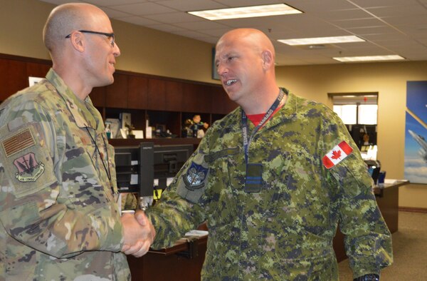 Chaplain (Maj.) Rudy Olivo, Component Numbered Air Force Chaplain, Continental U.S. NORAD Region-1st Air Force (Air Forces Northern), is congratulated by Royal Canadian Air Force Capt. Charles MacDonald, on Olivo's selection as the 2018 Samuel Stone Award, Air National Guard Chaplain of the Year. (U.S. Air Force photo by Mary McHale)