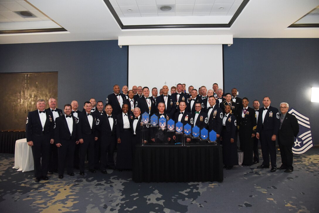 Recently inducted Chief Master Sergeants pose in front of current Chief Master Sergeants at the recognition ceremony in Melbourne, Fla., April 5, 2019. Eight Chief's from the 920th Rescue Wing were recognized during the ceremony, 11 total from Patrick Air Force Base, Florida, becoming one percent of the Air Force. (U.S. Air Force photo by Senior Airman Cali Elliott)