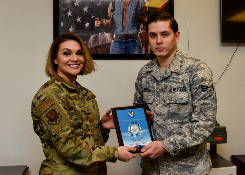 U.S. Air Force Senior Airman Justin Porter, 377th Maintenance Squadron munition operations technician, receives the March Diamond Sharp award from Master Sgt. Robbie Powell-Greenwood, 377th MXS acting first sergeant, at Kirtland Air Force Base, N.M., April 12, 2019. Porter worked directly with the 58th Special Operations Wing plans and scheduling section and correctly calculated requirements for 40 aircraft and coordinated the delivery of over 1.5 million munitions, fulfilling the demands of a $2.4 billion fleet. This resulted in 112 successful combat search and rescue training sorties and the certification of 166 Special Warfare (Battlefield) Airmen. (U.S. Air Force photo by Airman 1st Class Austin J. Prisbrey)