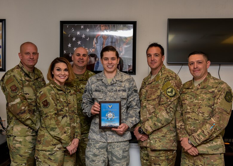 U.S. Air Force Senior Airman Justin Porter (center), and members of Team Kirtland First Sergeants pose for a photo at Kirtland Air Force Base, N.M., April 12, 2019. Porter worked directly with the 58th Special Operations Wing plans and scheduling section and correctly calculated requirements for 40 aircraft and coordinated the delivery of over 1.5 million munitions, fulfilling the demands of a $2.4 billion fleet. This resulted in 112 successful combat search and rescue training sorties and the certification of 166 Special Warfare (Battlefield) Airmen. (U.S. Air Force photo by Airman 1st Class Austin J. Prisbrey)