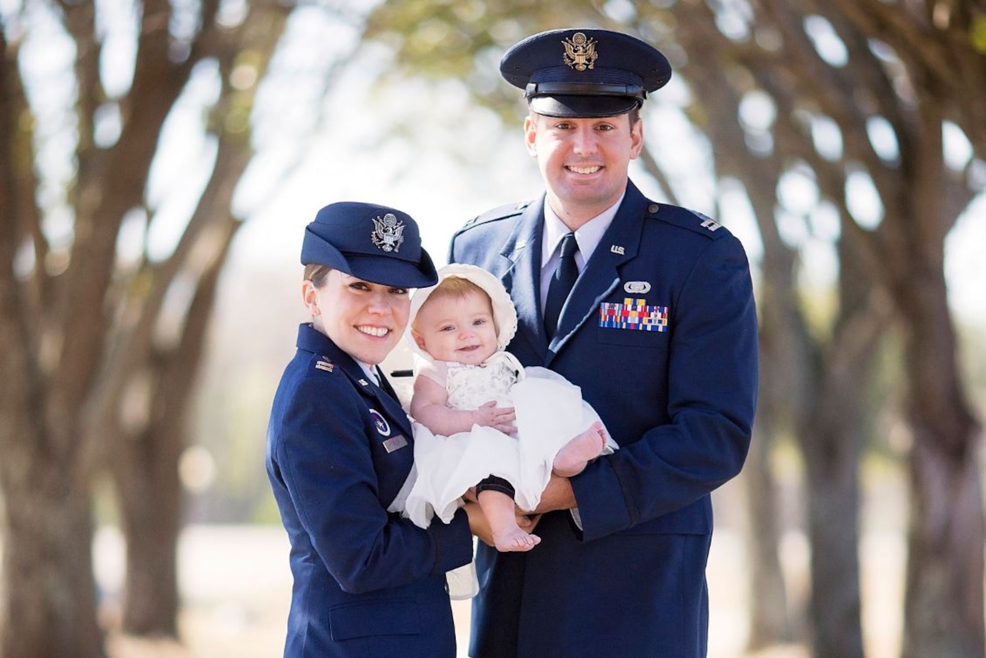 Two people holding a baby