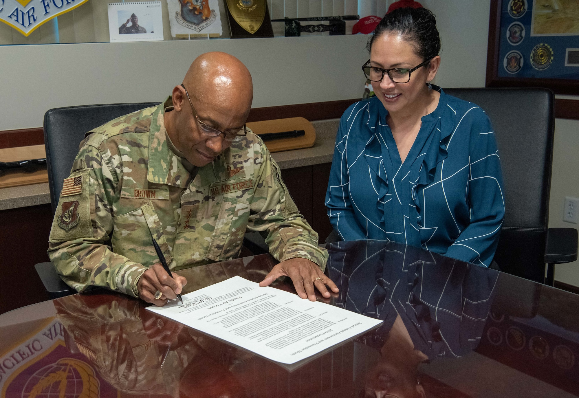 Gen. CQ Brown, Jr., Pacific Air Forces commander, signs a Sexual Assault Awareness and Prevention Month proclamation alongside Dr. Lisa Charles, Pacific Air Forces Sexual Assault Prevention and Response program manager, at Joint Base Pearl Harbor-Hickam, Hawaii, Mar. 11, 2019.