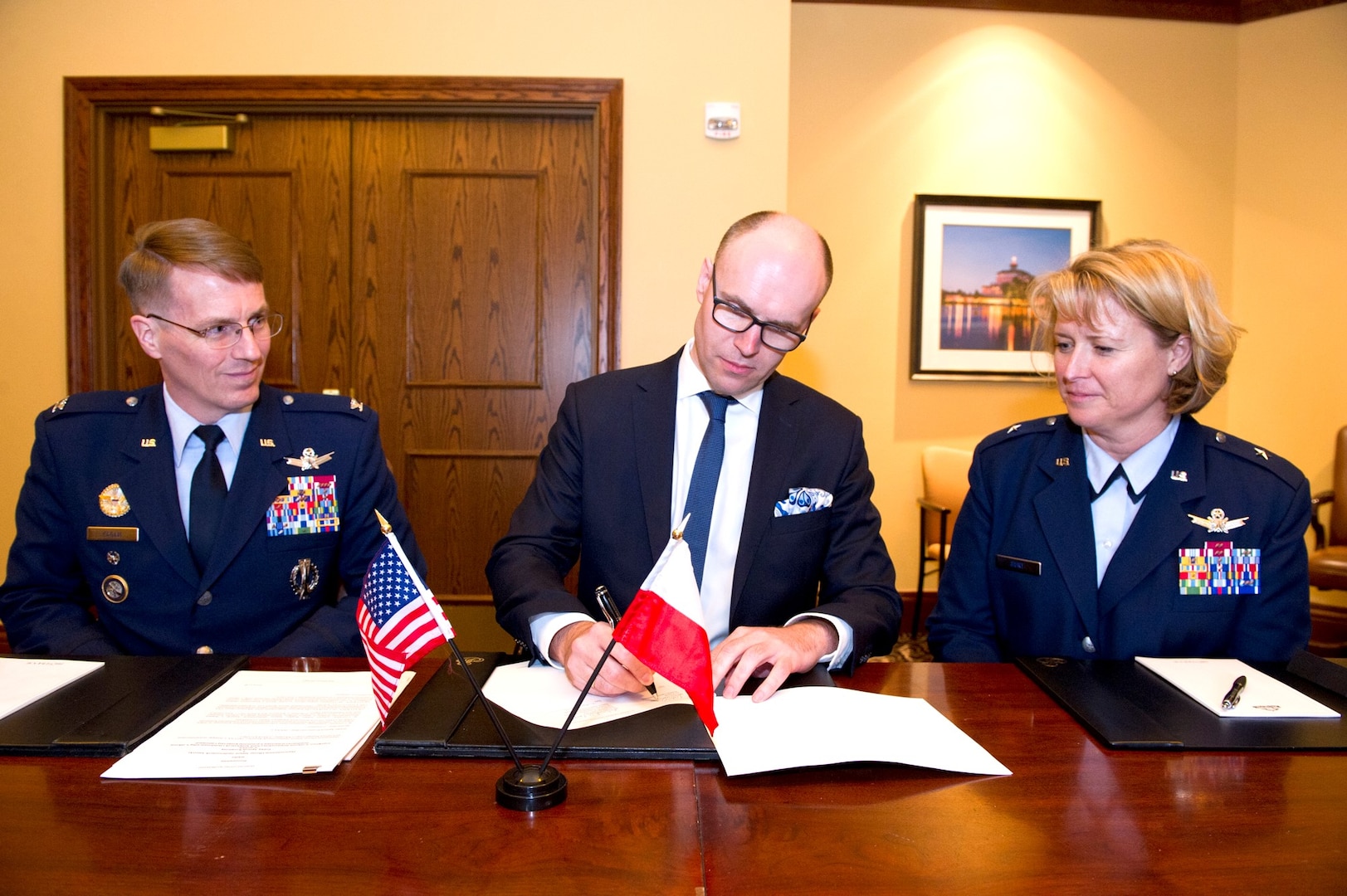 Michal Szaniawski, acting president of the Polish Space Agency, signs an agreement for space situational awareness (SSA) services and data as U.S. Space representative U.S. Air Force Col. Christopher Eagan (left), chief of Policy Division, U.S. Strategic Command (USSTRATCOM), and U.S. Air Force Brig. Gen.  Deanna Burt, director of Operations and Communications, U.S. Air Force Space Command, witnessed the signing. Szaniawski signed the agreement as part of a larger effort to support spaceflight planning and enhance the safety, stability and sustainability of space operations. Poland joins 18 nations, two intergovernmental organizations, and 77 commercial satellite owners, operators, launchers already participating in SSA data-sharing agreements with USSTRATCOM.