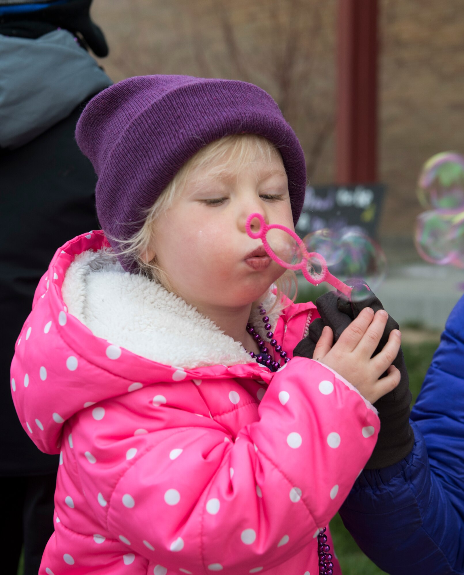 A child blows bubbles before school April 12, 2019, at Mountain Home Air Force Base, Idaho. Gunfighter kids are celebrated every year during the Month of the Military Child. (U.S. Air Force Photo by Airman 1st Class Hailey Bivens)