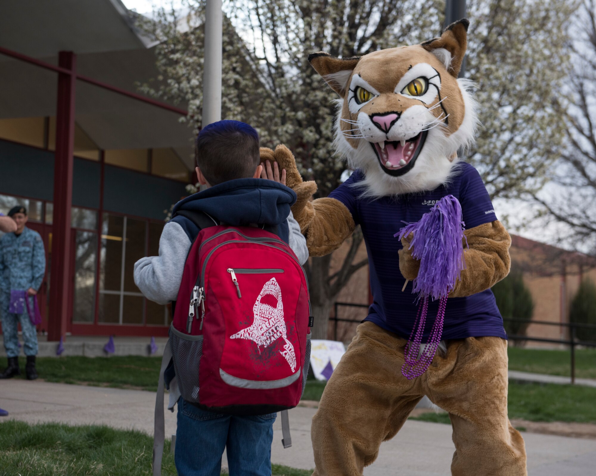 Bobby McBobface, 366th Force Support Squadron mascot, high-fives a child as he arrives to school April 12, 2019, at Mountain Home Air Force Base, Idaho. MHAFB personnel celebrated children as a part of the Month of the Military Child. (U.S. Air Force Photo by Airman 1st Class Hailey Bivens)