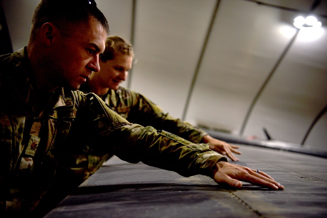 U.S. Air Force 1st Lt. M. Rebecca Kretzer, 380th Expeditionary Maintenance Group Depot Liaison Engineer, discusses potential maintenance requests during turnover with her replacement, Maj. Joseph Czabaranek, April 11, 2019.