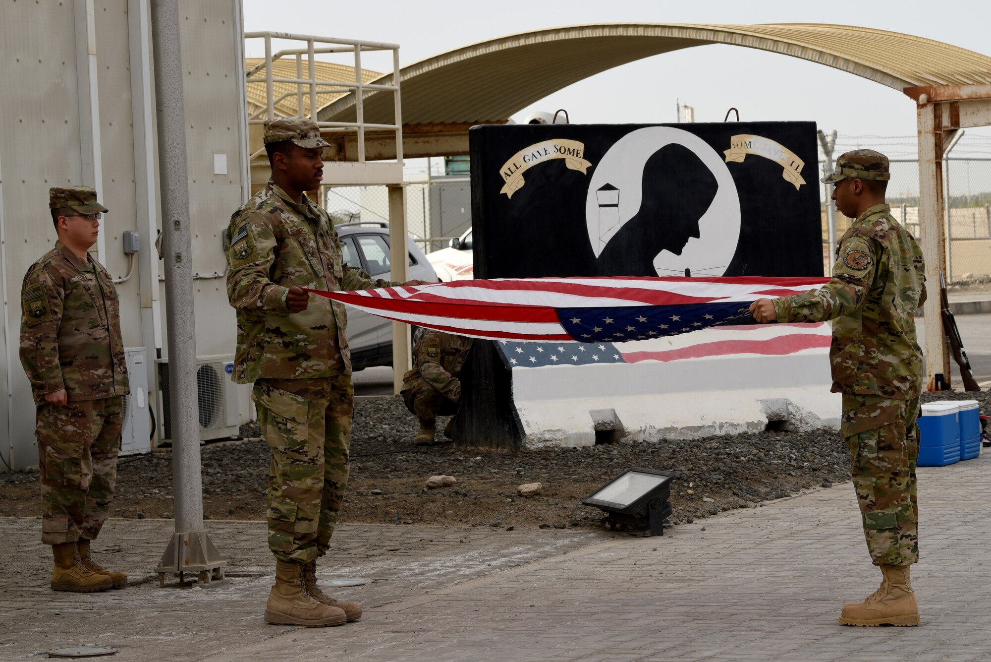 The 380th Air Expeditionary Wing Honor Guard flag detail volunteers fold the American flag as part of a monthly retreat ceremony on Al Dhafra Air Base, United Arab Emirates, April 5, 2019.
