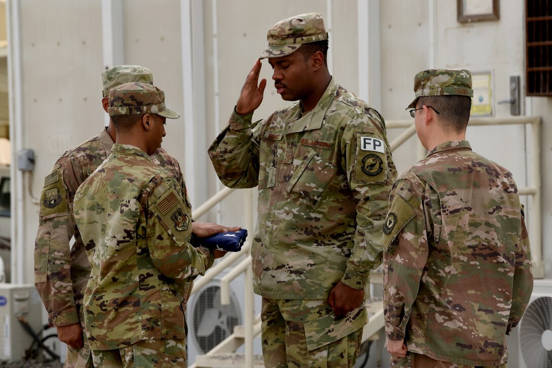Members of the 380th Air Expeditionary Wing Honor Guard flag detail pay respects to the flag during a monthly retreat ceremony on Al Dhafra Air Base, United Arab Emirates, April 5, 2019.