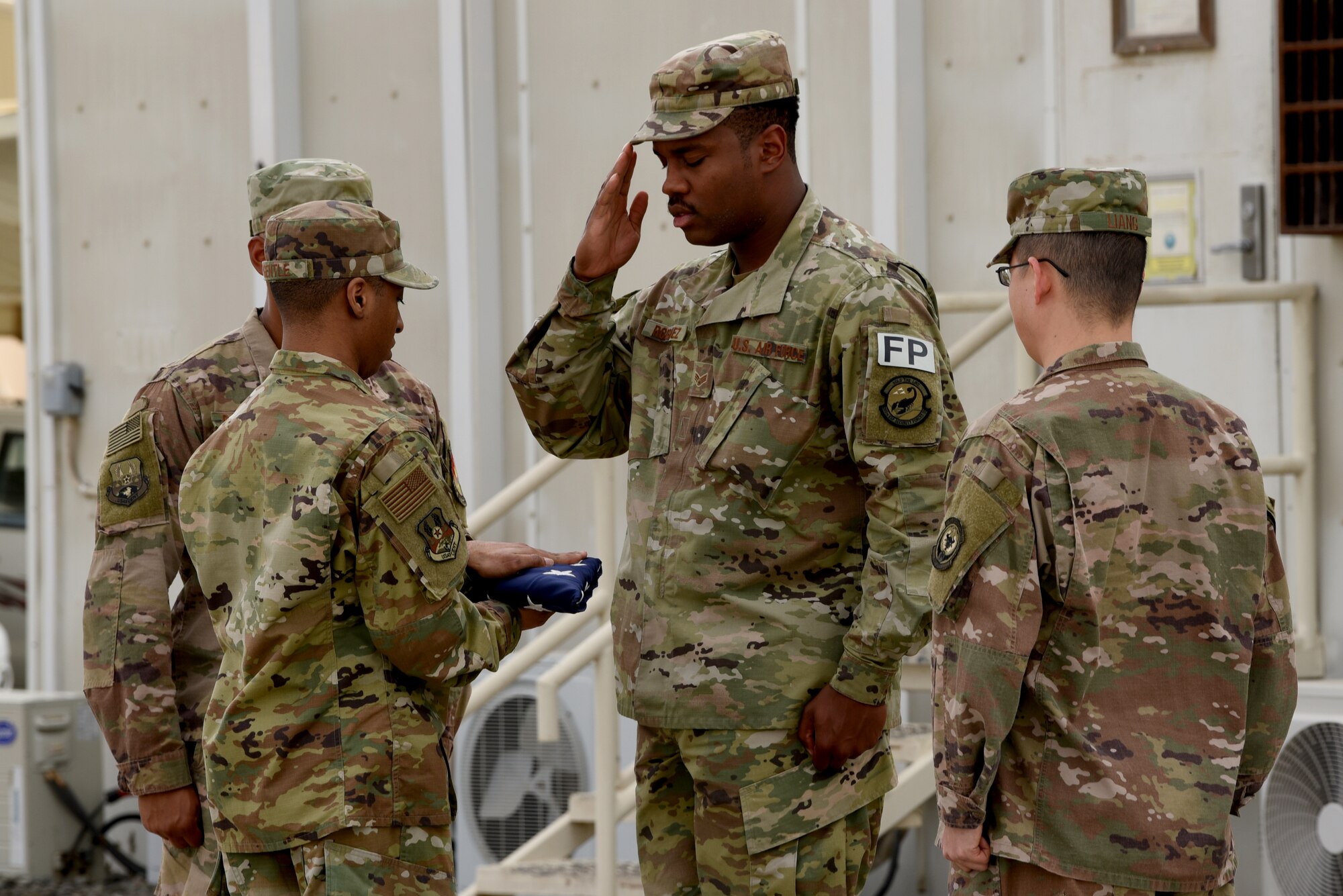Members of the 380th Air Expeditionary Wing Honor Guard flag detail pay respects to the flag during a monthly retreat ceremony on Al Dhafra Air Base, United Arab Emirates, April 5, 2019.