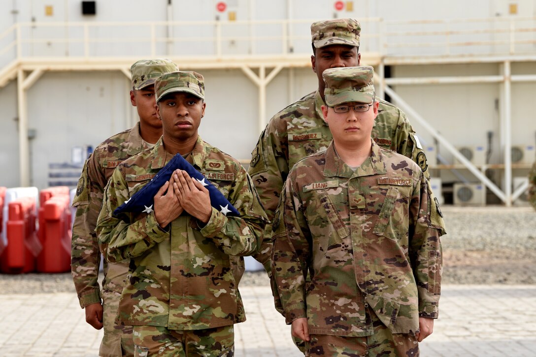 Members of the 380th Air Expeditionary Wing Honor Guard flag detail secure the flag proceeding a monthly retreat ceremony on Al Dhafra Air Base, United Arab Emirates, April 5, 2019.