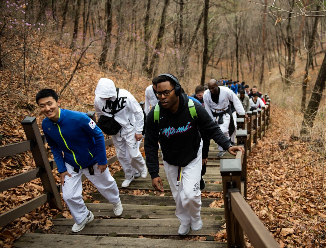 Members from the United States Forces-Korea and Republic of Korea Army hike up a hill during a Korean Ministry of Defense tour at Muju, Republic of Korea, April 9, 2019. One of the sites visited on the tour was an observatory that overlooks the city of Muju and is decorated with murals honoring the sport of Taekwondo. (U.S. Air Force photo by Senior Airman Stefan Alvarez)