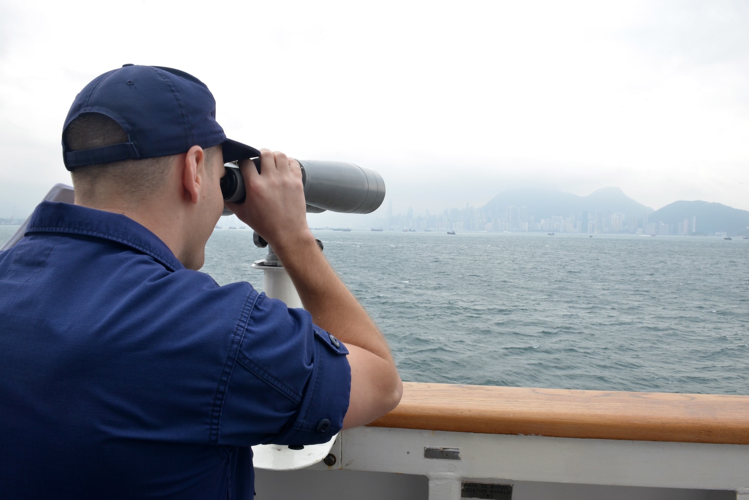 U.S. Coast Guard Petty Officer 3rd Class Brendan Hoban, a U.S. Coast Guard Cutter Bertholf (WMSL 750) crewmember, uses a set of big eyes as the cutter navigates toward Hong Kong, April 15, 2019. Bertholf’s visit to Hong Kong marks the first time a U.S. Coast Guard vessel has moored in the city in 17 years. U.S Coast Guard photo by