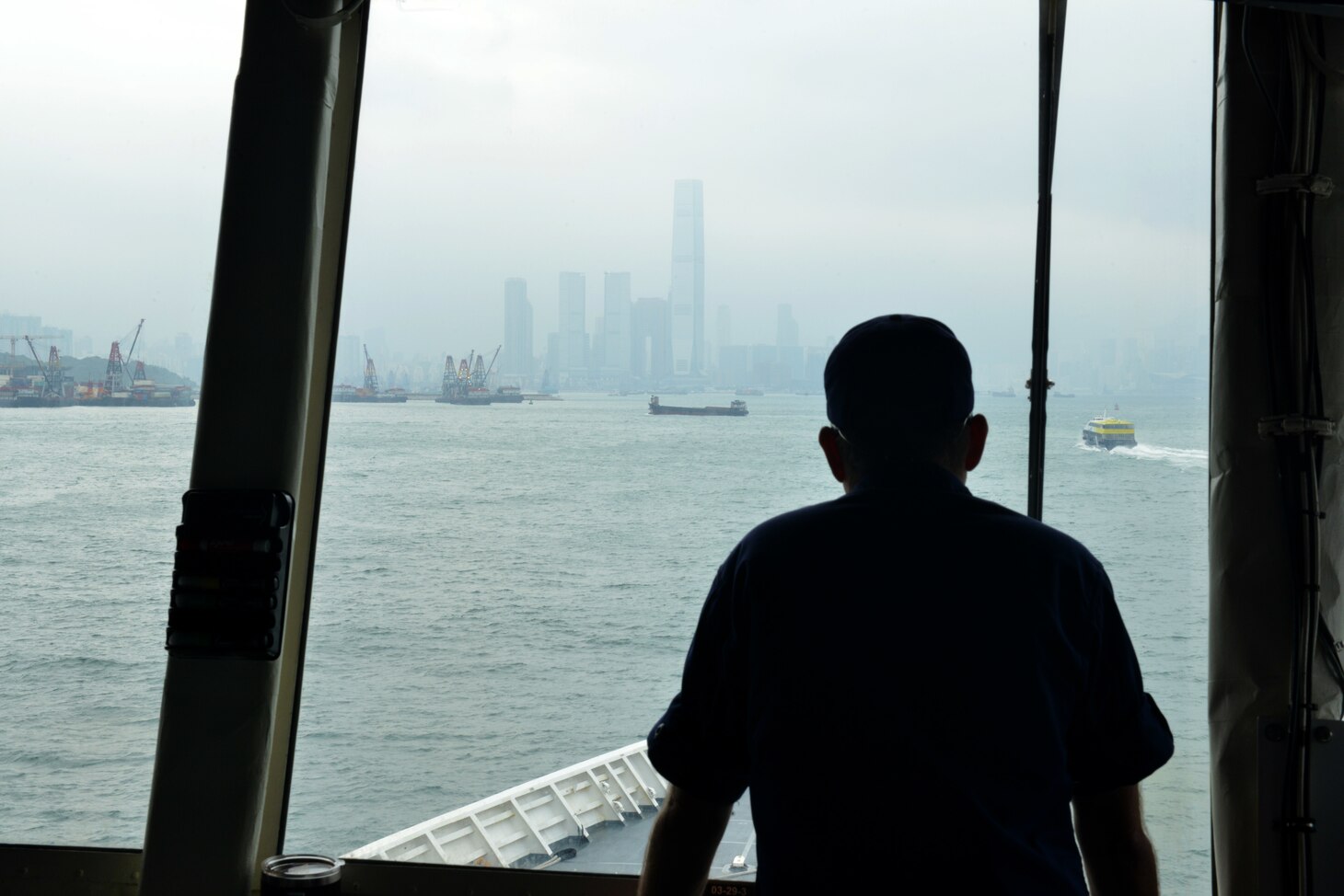 U.S. Coast Guard Cmdr. Robert Hill, executive officer of the U.S. Coast Guard Cutter Bertholf (WMSL 750), looks through the bridge windows as the cutter navigates toward Hong Kong, April 15, 2019. Under the tactical control of Commander, 7th Fleet, Bertholf will patrol and operate as directed, while striving to improve regional maritime governance and security, through capacity building exercises and professional exchanges with numerous partner nations and their respective coast guards and navies.