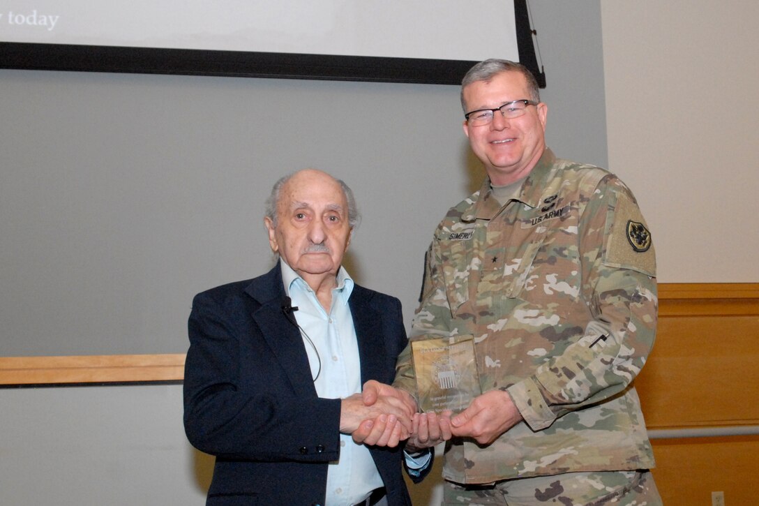 David Tuck, left, Holocaust survivor receives a plaque from Army Brig. Gen. Mark Simerly, DLA Troop Support commander, right, during the Holocaust Observance Program April 10 in Philadelphia. Tuck served as the keynote speaker for the event. (Photo by Ed Maldonado)