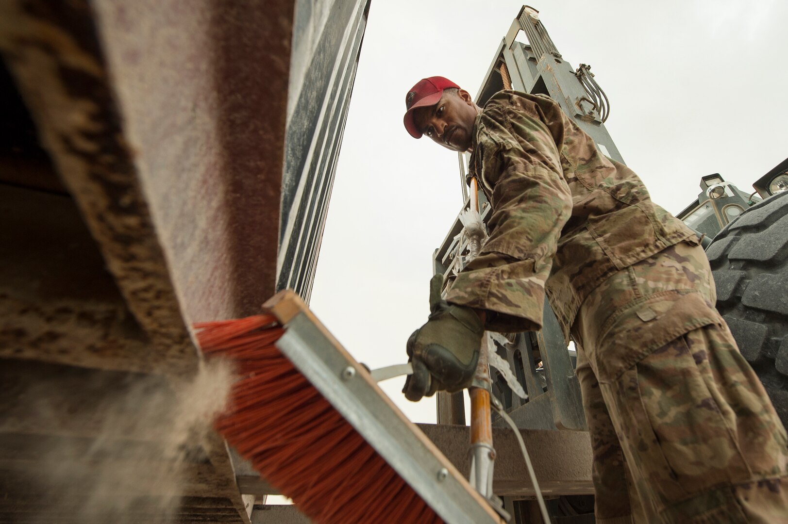 Staff Sgt. Sterling Benford, 557th Expeditionary RED HORSE Squadron supply NCO in charge, sweeps the edges of a large container in preparation for transport at Al Udeid Air Base, Qatar, April 3, 2019. Benford is responsible for the accountability of 1st Expeditionary Civil Engineer Group assets at deployed locations across U.S. Central Command (CENTCOM). Logistics Airmen were vital in the completion of more than 400 construction missions across the CENTCOM Theater during a six-month period. (U.S. Air Force photo by Tech. Sgt. Christopher Hubenthal)