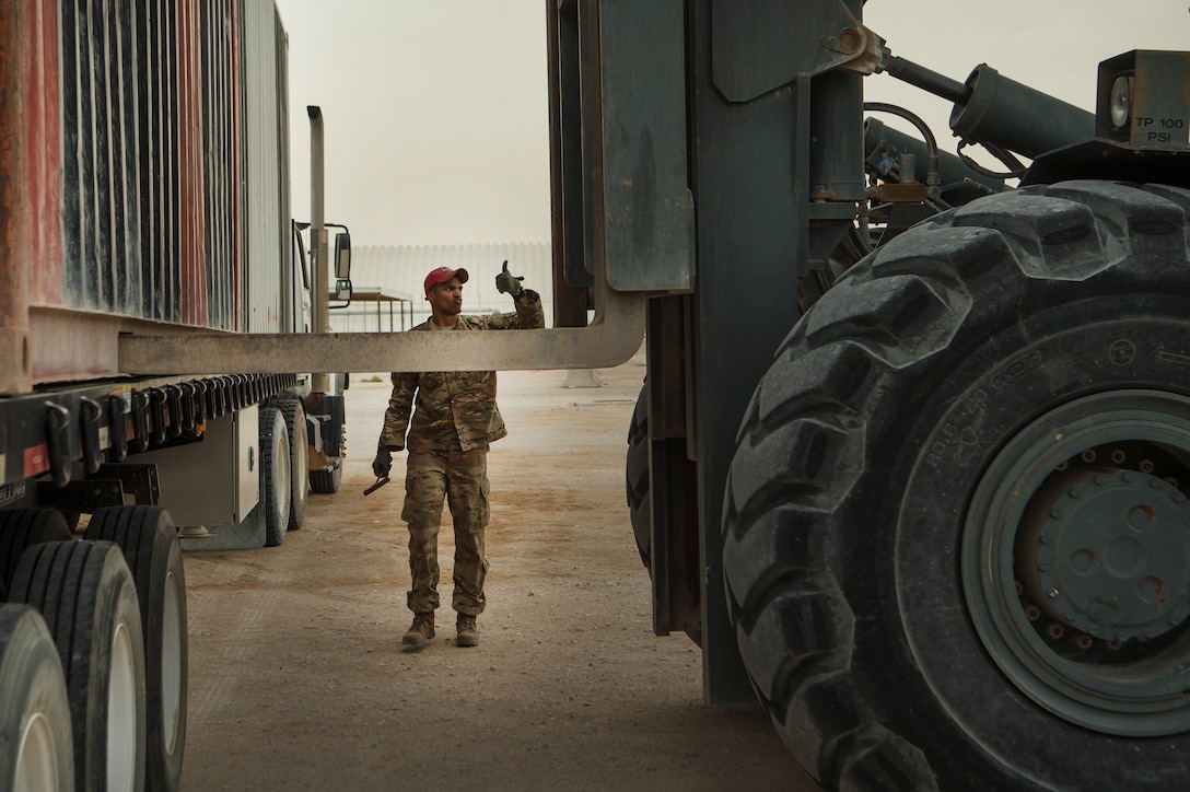 Staff Sgt. Sterling Benford, 557th Expeditionary RED HORSE Squadron supply NCO in charge, guides the movement of a large container at Al Udeid Air Base, Qatar, April 3, 2019. Benford is responsible for the accountability of 1st Expeditionary Civil Engineer Group assets at deployed locations across U.S. Central Command (CENTCOM). Logistics Airmen were vital in the completion of more than 400 construction missions across the CENTCOM Theater during a six-month period. (U.S. Air Force photo by Tech. Sgt. Christopher Hubenthal)