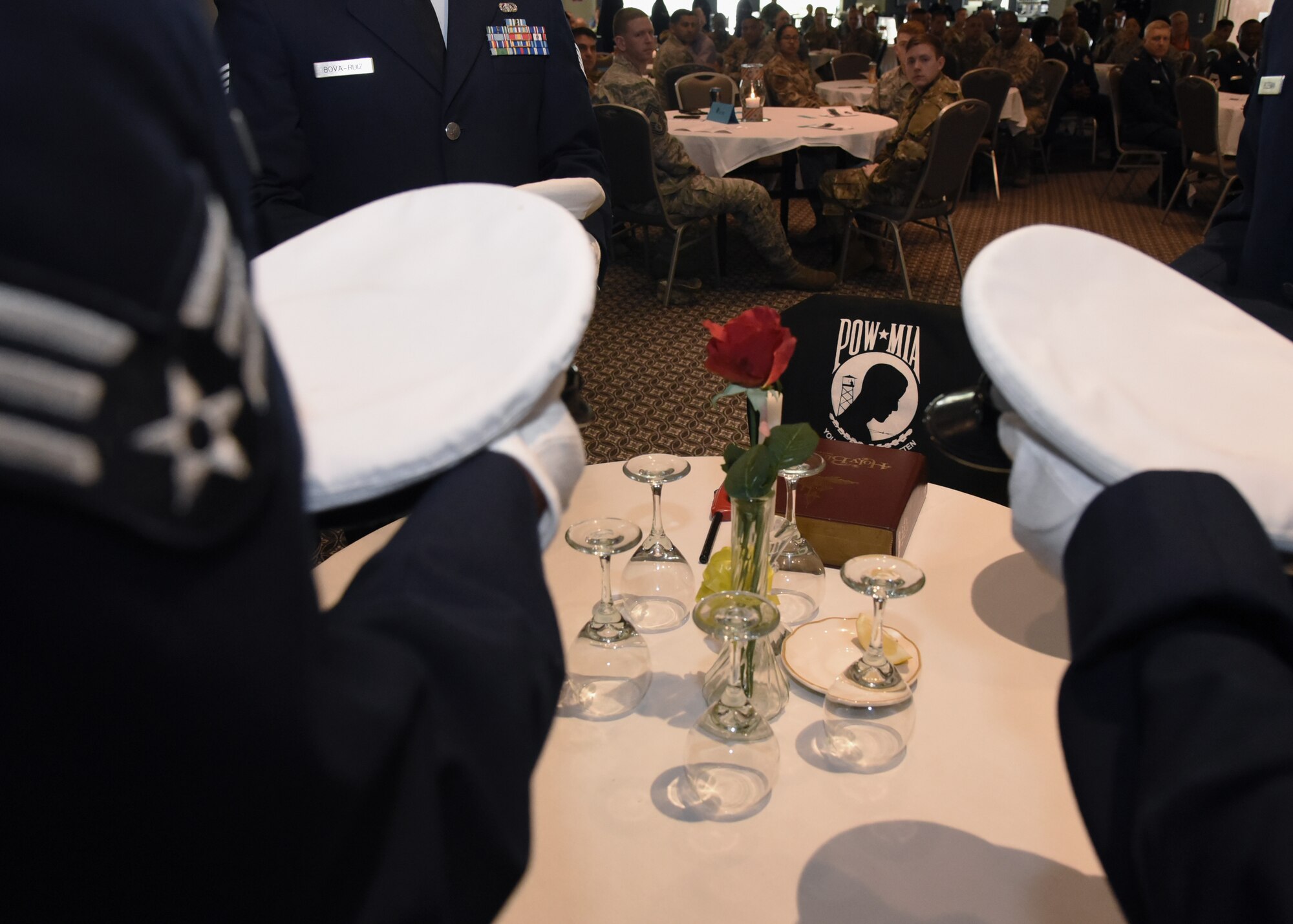 U.S. Air Force Airman Leadership School graduates set the POW/MIA with service hats from each of the branches during the ALS Graduation Ceremony in the Event Center at Goodfellow Air Force Base, Texas, April 11, 2019. The POW/MIA Table holds a place of honor during special events in memory of military members that are missing, have fallen or captured by enemies. (U.S. Air Force Photo by Airman 1st Class Abbey Rieves/Released)