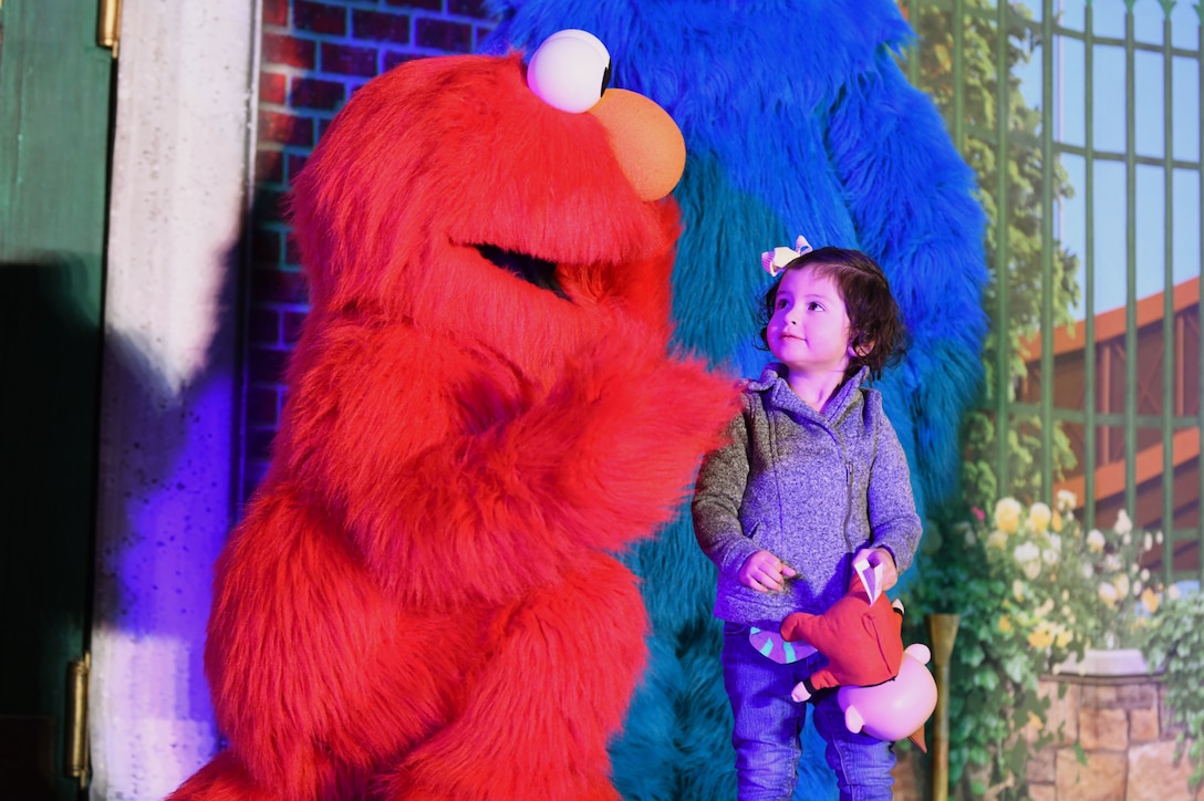 Audriana Escobedo, the daughter of Matthew Escobedo, a 28th Operations Support Squadron aircrew flight equipment technician, meets Elmo prior to the start of Sesame Street Live, at the base theater on Ellsworth Air Force Base, S.D., March 28, 2019.  Families were able to get up close and personal with their favorite characters while singing, dancing and learning about the importance of community. (U.S. Air Force photo by Airman 1st Class Christina Bennett)