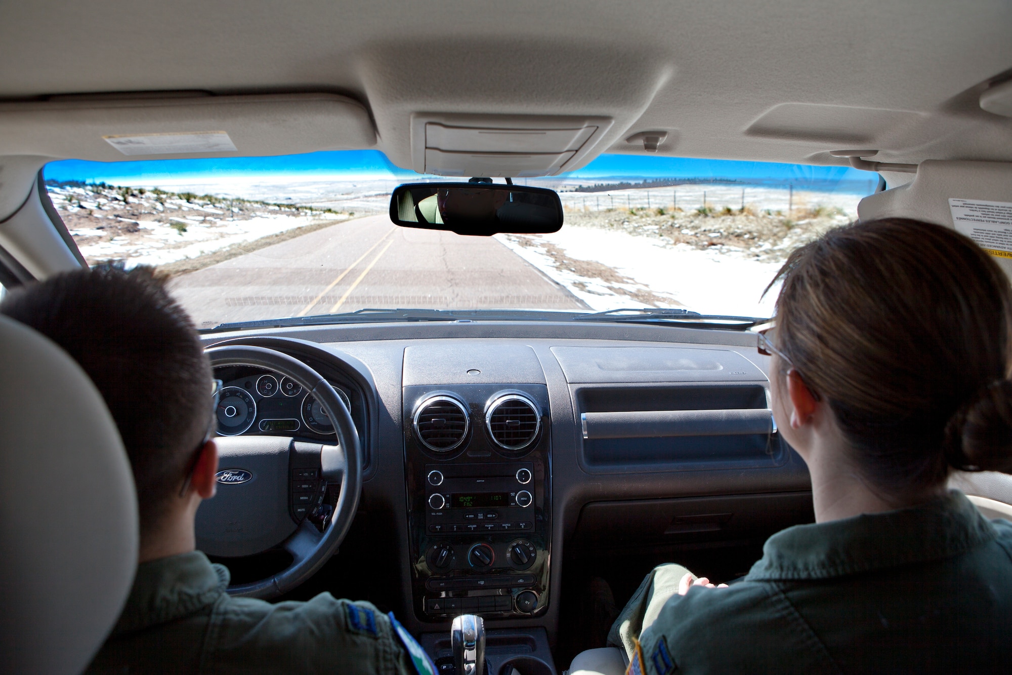 In this file photo, Capt. Aaron Alam, 321st Missile Squadron ICBM deputy combat crew commander, and Capt. Caitlin Olson, 321st Missile Squadron ICBM combat crew commander, drive through Nebraska to reach a missile alert facility. The TCF provides Airmen that trip out to the field updated weather and road conditions. (U.S. Air Force photo by 2nd Lt. Christen Downing)