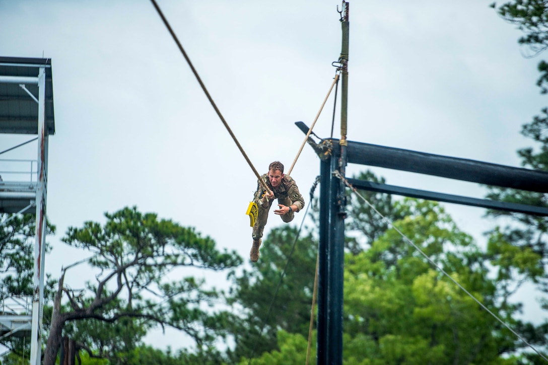 A soldier slides down a rope.