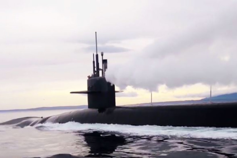 An image of the upper portion of a nuclear submarine in a body of water.