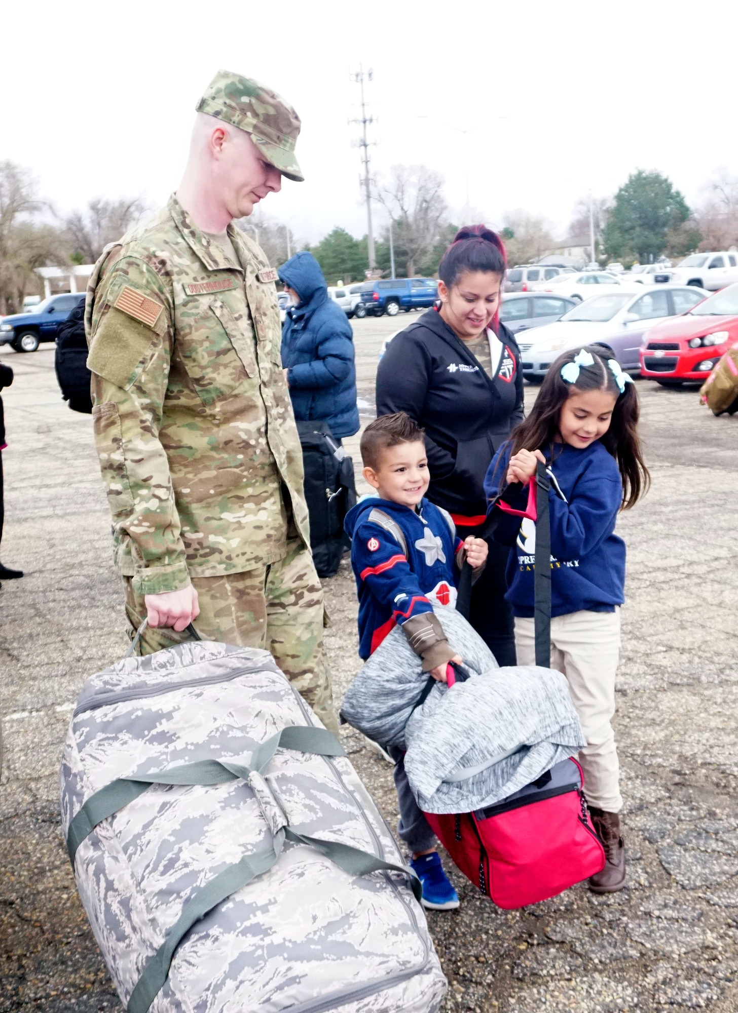 Hunter and Juliana, children of Tech. Sgt. Dylan Oosterhouse and wife Anna, help load their dad’s deployment bags at Hill Air Force Base, Utah
