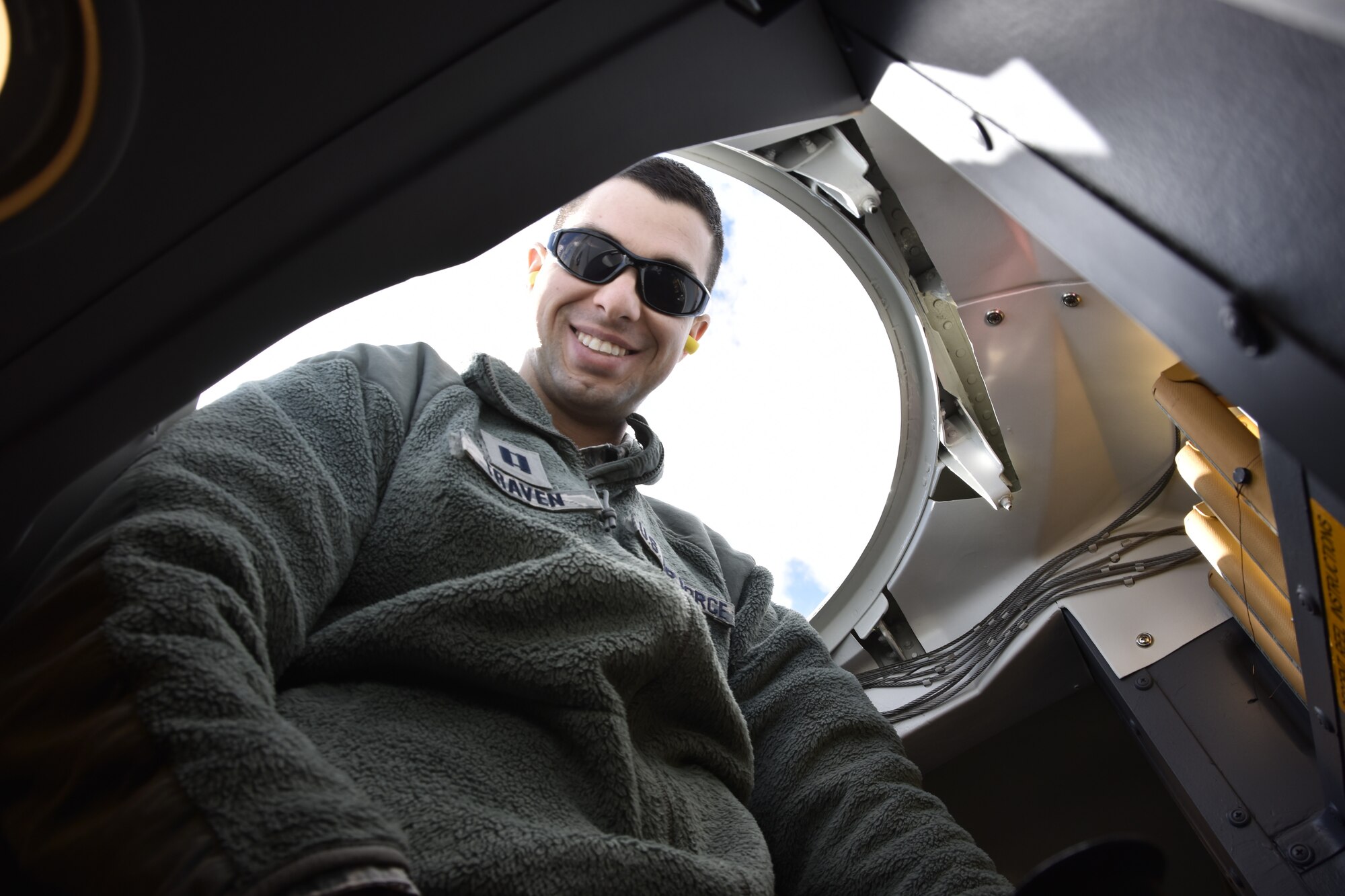 Capt. Victor Traven, a systems and logistics class instructor from Wright Patterson Air Force Base, looks down from a latch opening inside a C-5M Super Galaxy parked on the tarmac at Westover Air Reserve Base.