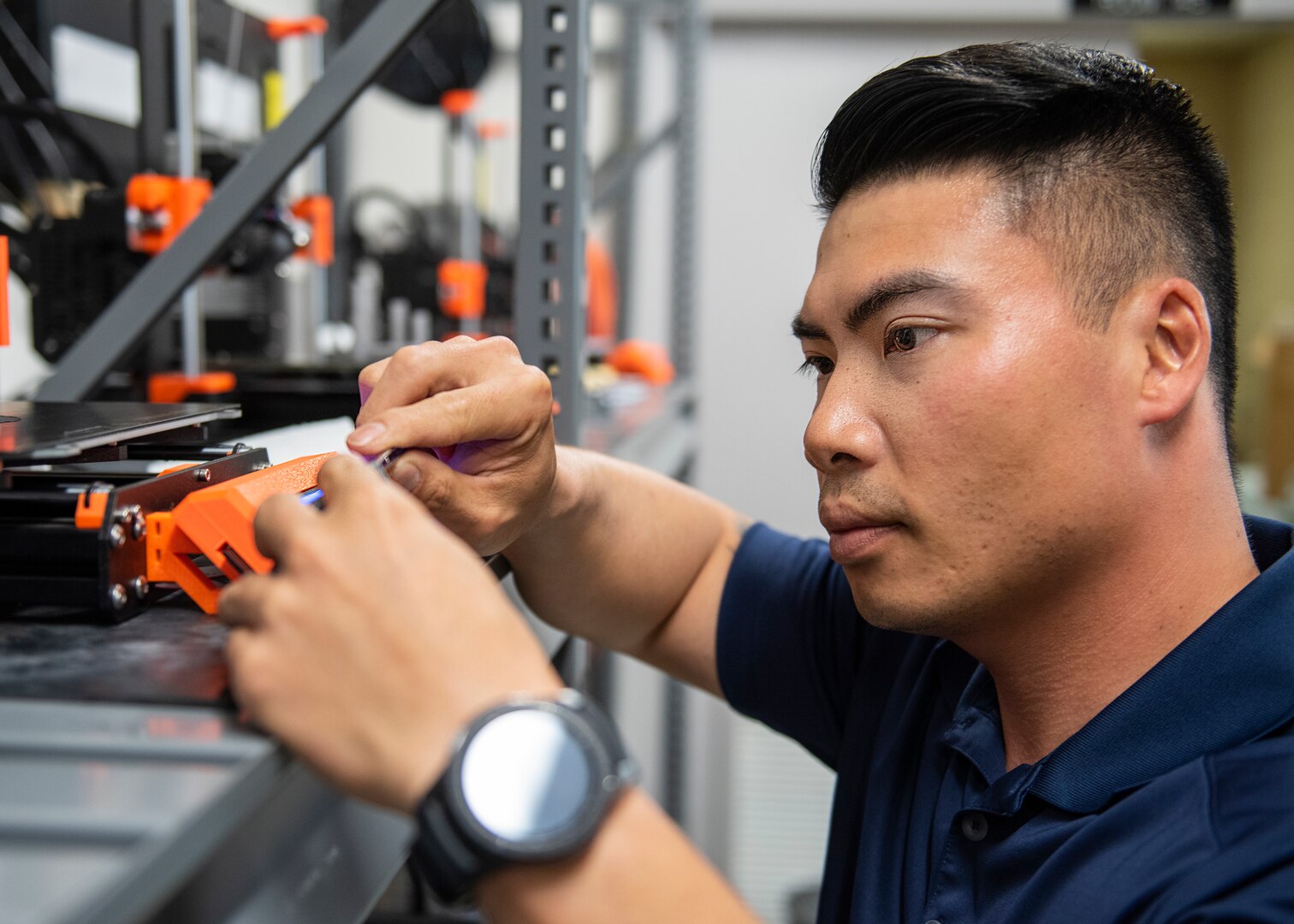 Naval Surface Warfare Center Panama City Division employee Bryan Tien Le uses a three dimensional printer to fabricate a part for one of the diver assisting units he works on. U.S. Navy photo by Eddie Green