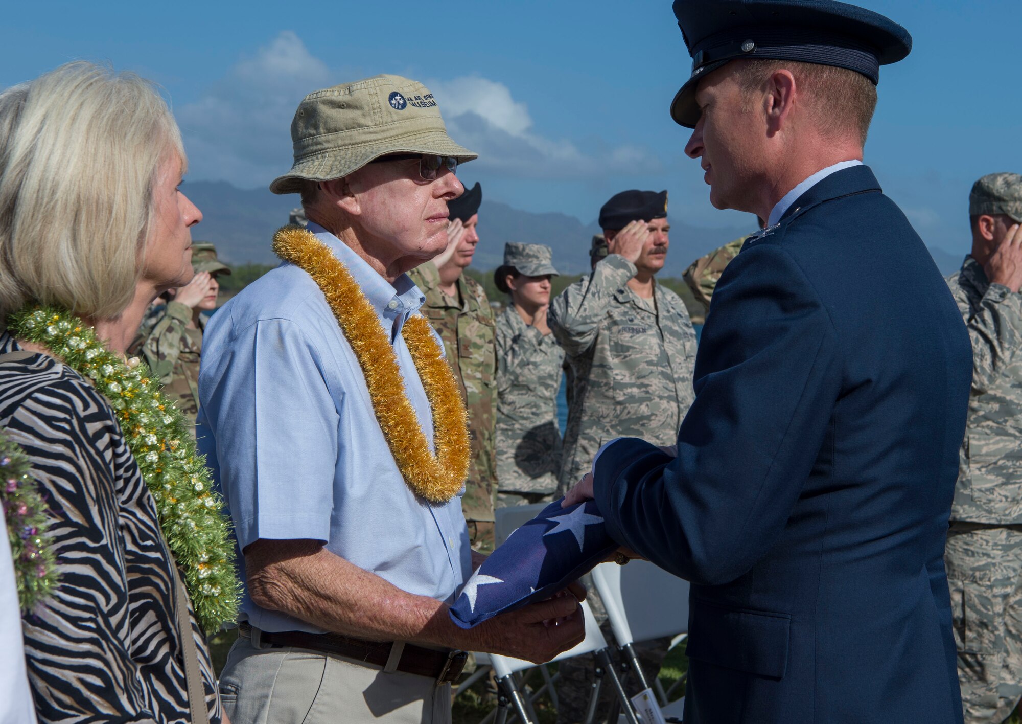 Col. Halsey Burks, 15th Wing commander, gives an American Flag to Bob Harris, during a memorial service held for retired Master Sgt. Byram Bates at the Missing Man Memorial on Joint Base Pearl Harbor-Hickam, Hawaii, April 12, 2019. Harris is the closest living member to Bates, who was a survivor of the Dec. 7, 1941 attack. (U.S. Air Force photo by Tech. Sgt. Heather Redman)