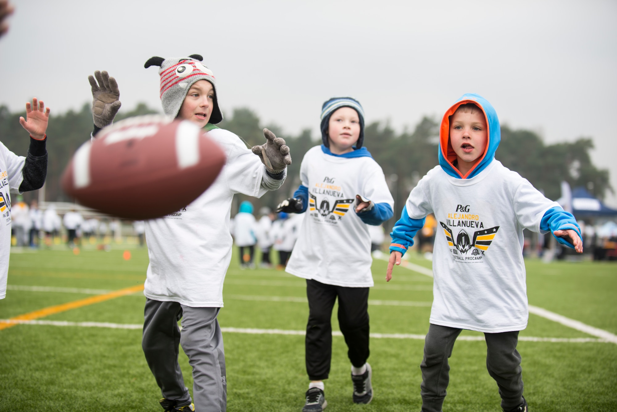 Alejandro Villanueva football camp attendees attempt to catch a football while practicing offensive drills during the Alejandro Villanueva football camp at Kaiserslautern High School on Vogelweh Military Complex, Germany, April 14, 2019. More than 200 children participated in the two-day camp focusing on football fundamentals. (U.S. Air Force photo by Staff Sgt. Jonathan Bass)