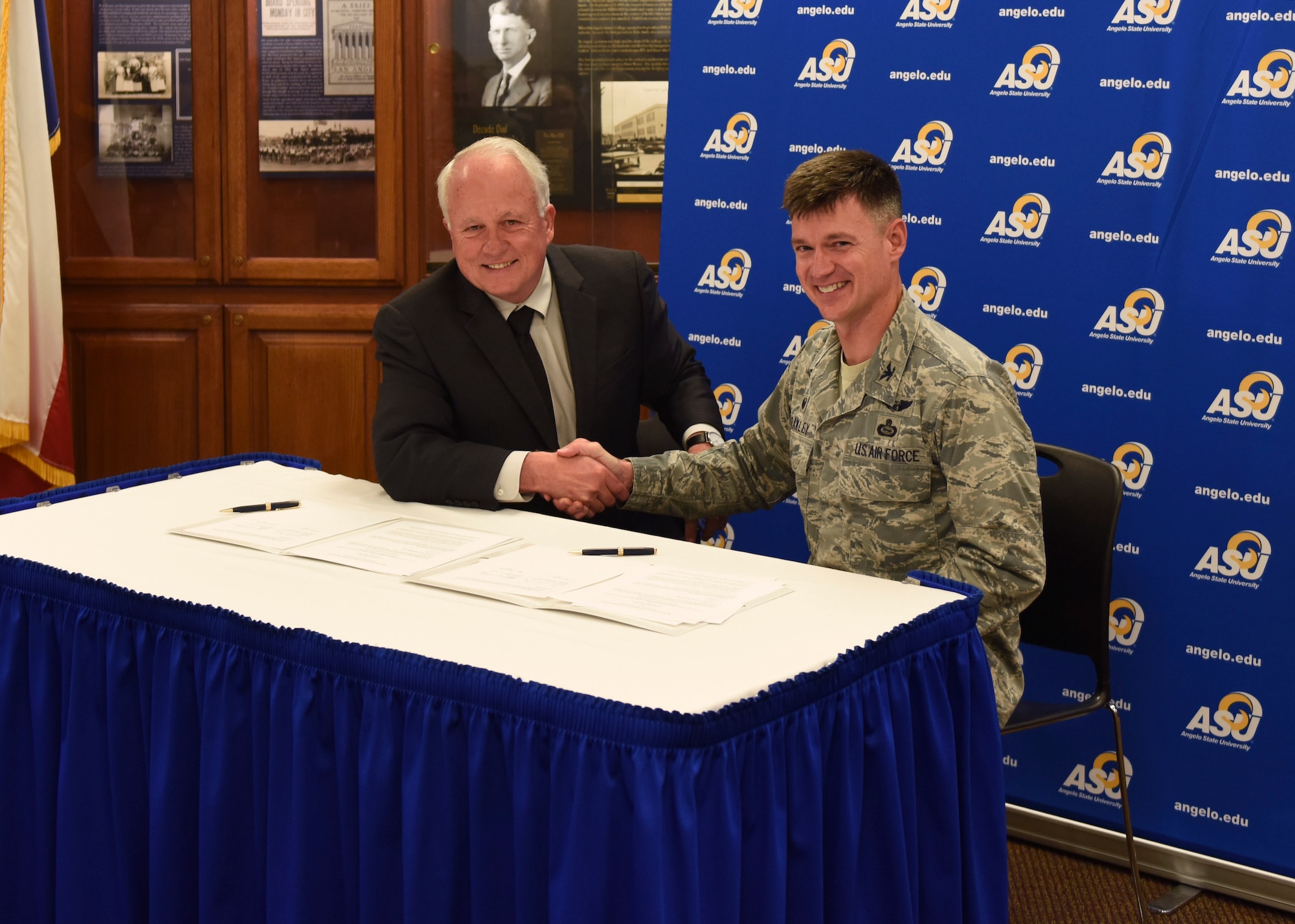 Angelo State University President, Dr. Brian May and U.S. Air Force Col. Thomas Coakley, 17th Training Group commander, shake hands after signing the Memorandum of Understanding at ASU, Texas, April 15, 2019. The MOU allows 14N professionals to transfer 12 credit hours toward two master’s degree through Angelo State University (U.S. Air Force photo by Airman 1st Class Zachary Chapman/Released)