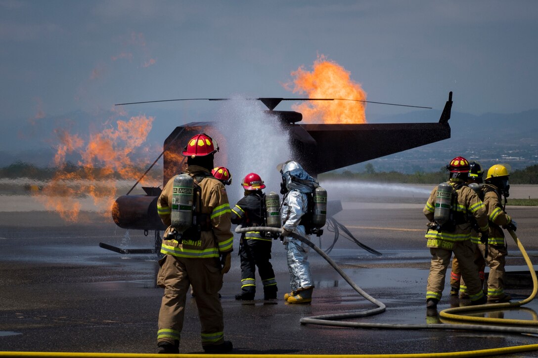 A team comprised of Central American firefighters extinguish a flame in a simulated helicopter during the Central America Sharing Mutual Operational Knowledge and Experiences (CENTAM SMOKE) exercise, April 1, 2019, at Soto Cano Air Base, Honduras. CENTAM SMOKE brought together firefighters from Honduras, Costa Rica, Belize, Guatemala and El Salvador to train with U.S. Air Force members as well as develop bonds and understandings of one another’s culture with team building exercises. The weeklong training included aircraft and structural fires, vehicle extrication, and a firefighter combat challenge. (U.S. Air Force photo by Staff Sgt. Eric Summers Jr.)