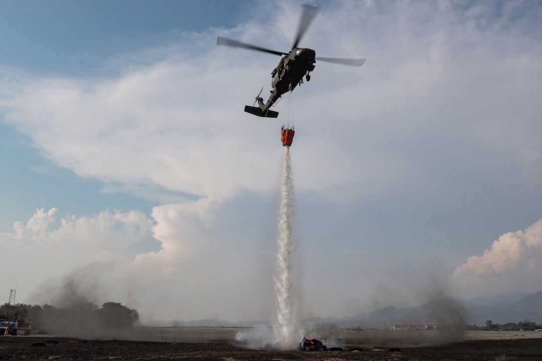 A UH-60 Blackhawk from the 1-228th Aviation Regiment aims to extinguish a simulated wildfire to show the additional capabilities of Joint Task Force - Bravo during the Central America Sharing Mutual Operational Knowledge and Experiences (CENTAM SMOKE) exercise, April 11, 2019, at Soto Cano Air Base, Honduras. CENTAM SMOKE brought together firefighters from Honduras, Costa Rica, Belize, Guatemala and El Salvador to train with U.S. Air Force members as well as develop bonds and understandings of one another’s culture with team building exercises. The weeklong training included aircraft and structural fires, vehicle extrication, and a firefighter combat challenge. (U.S. Air Force photo by Staff Sgt. Eric Summers Jr.)