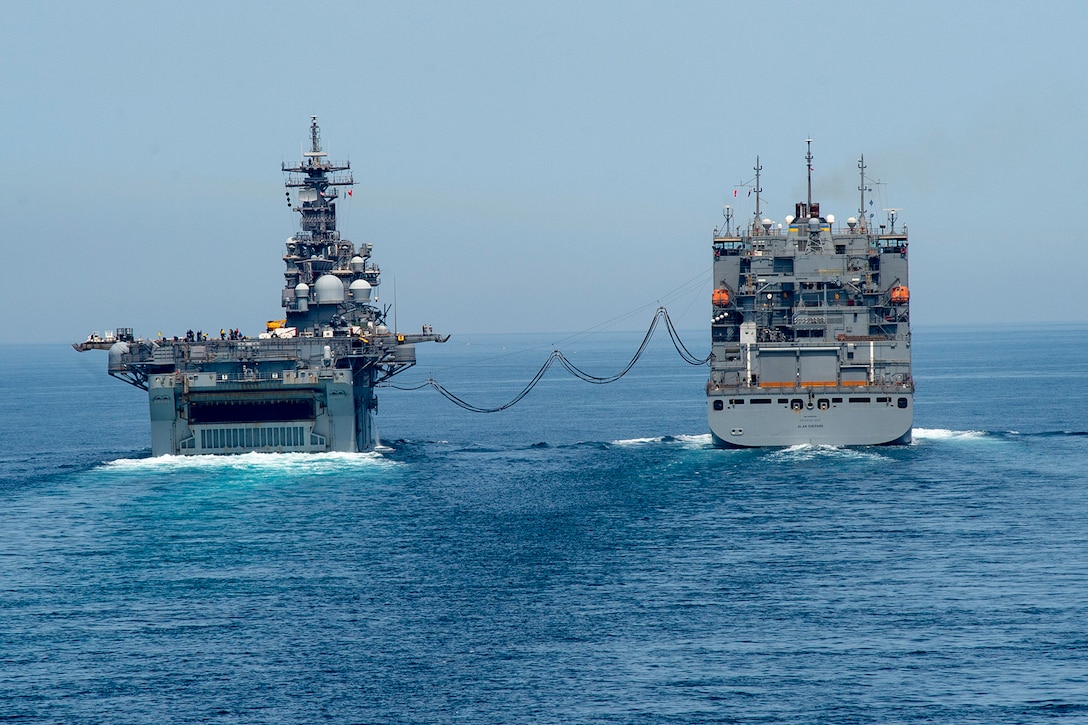 Two ships conduct a replenishment at sea.