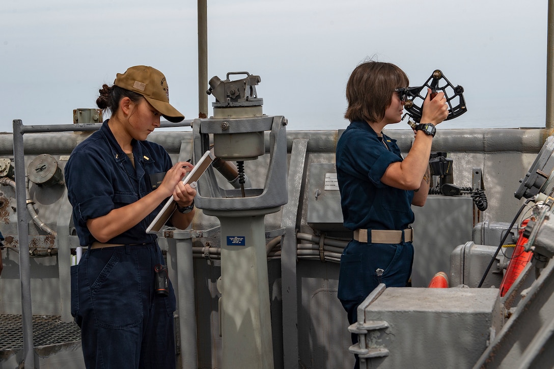 Sailors record distances during a replenishment at sea.