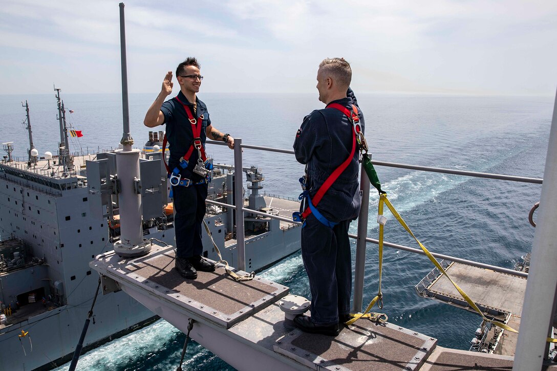 A sailor reenlists on a ship.