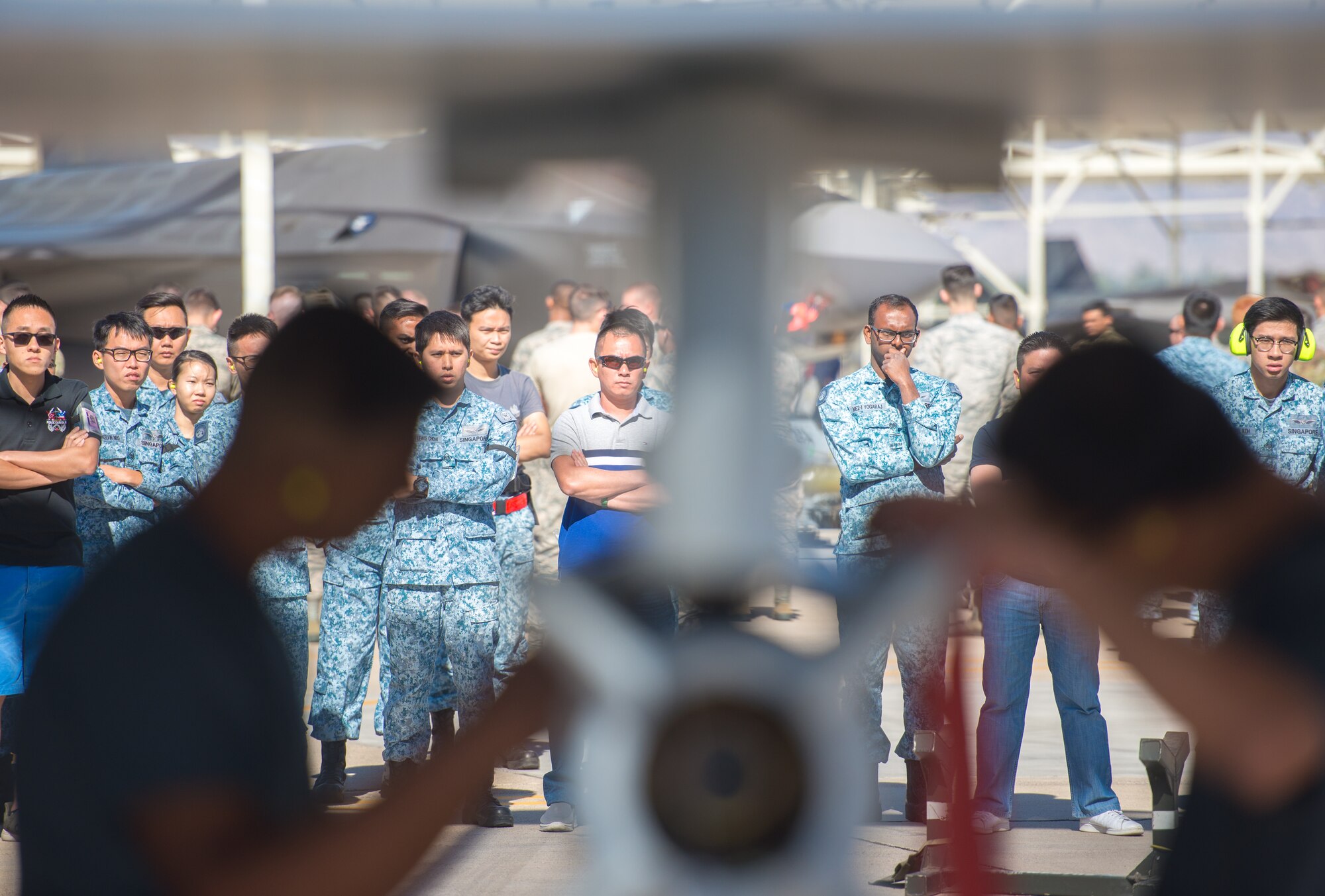 Spectators watch as Republic of Singapore Airmen assigned to the 425th Fighter Squadron load an inert missile onto an F-16 Fighting Falcon during the 1st Quarter Load Crew Competition, April 11, 2019, at Luke Air Force Base, Ariz.