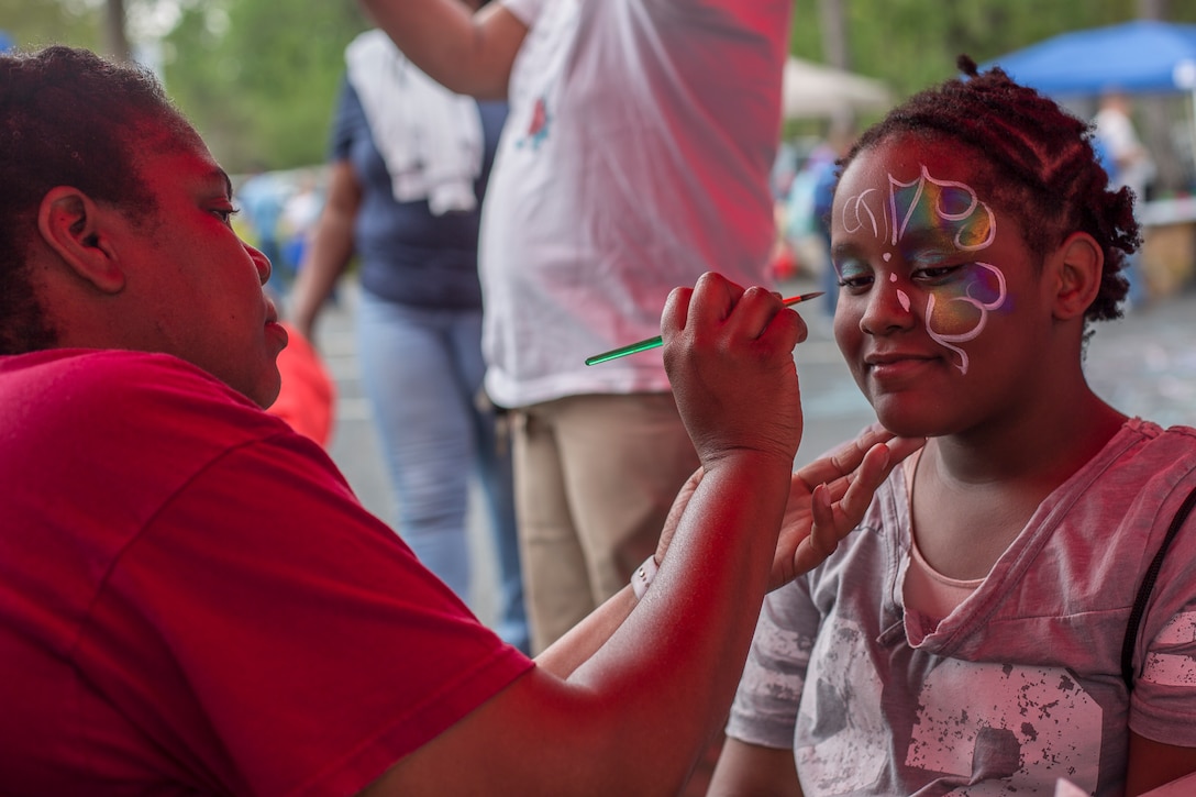 Tamika Curtis paints a child's face during KidFest in Beaufort, April 6. Curtis is a program assistant with Marine Corps Community Services South Carolina.
