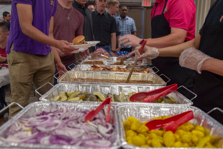 Members of the 97th Air Mobility Wing get food from a buffet line during the quarterly Committee of 100 dinner, April 15, 2019, at Altus, Okla. The Committee of 100 is a quarterly event hosted by the community of Altus to welcome newcomers, returning deployers and family members to Altus.