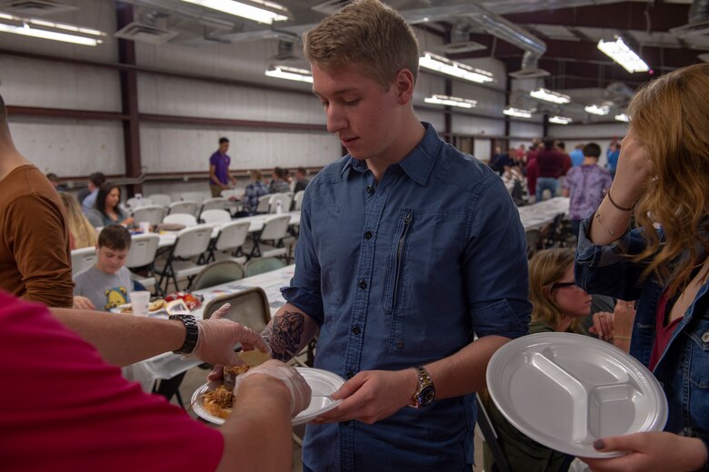 A student from the 97th Training Squadron receives food during the quarterly Committee of 100 dinner, April 15, 2019, at Altus, Okla. The Committee of 100 puts on a dinner celebration offering door prizes and games afterwards.