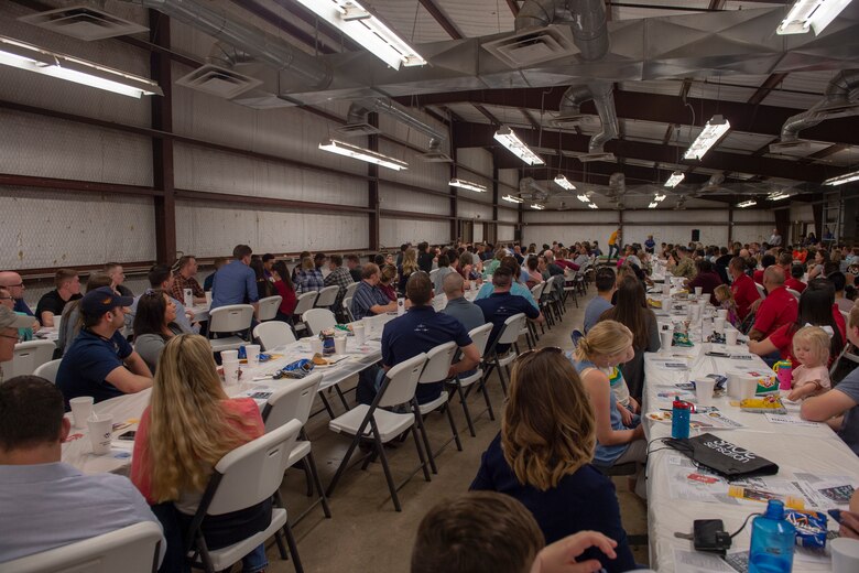 Newcomers, returning deployers and family members from the 97th Air Mobility Wing watch U.S. Air Force Col. William Mickley, 97th Operations Group commander, step onto the stage to introduce members from the 97th OG, April 15, 2019, at Altus, Okla. Commanders from each group stood up and introduced their members to the Committee of 100 to welcome them to Altus.