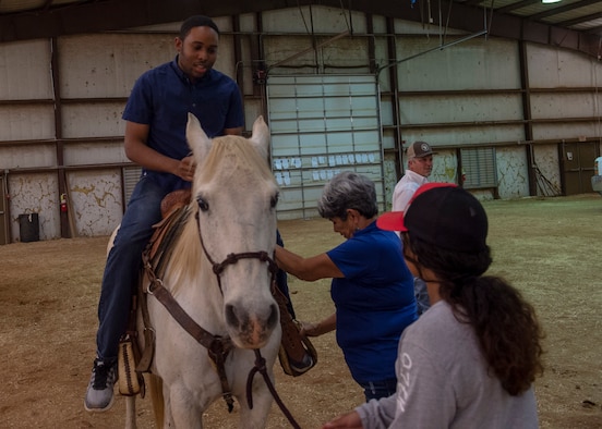 A student from the 97th Training Squadron rides a horse during the quarterly Committee of 100 dinner, April 15, 2019, at Altus, Okla. After the dinner and introductions, the members from the 97th Air Mobility Wing were able to ride horses and a mechanical bull while children jumped in bounce houses.