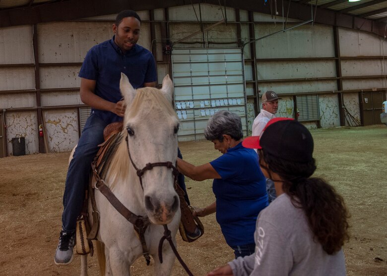 A student from the 97th Training Squadron rides a horse during the quarterly Committee of 100 dinner, April 15, 2019, at Altus, Okla. After the dinner and introductions, the members from the 97th Air Mobility Wing were able to ride horses and a mechanical bull while children jumped in bounce houses.