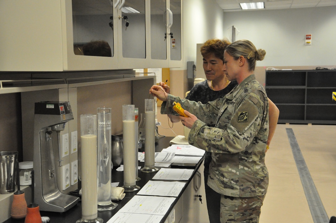 Staff Sgt. Kyla Stewart, a technical engineer in the Far East District (FED) materials testing laboratory learns the correct testing techniques from FED's material engineer, Song, Un-ho, April 11 at the Far East District headquarters, Camp Humphreys, Korea.