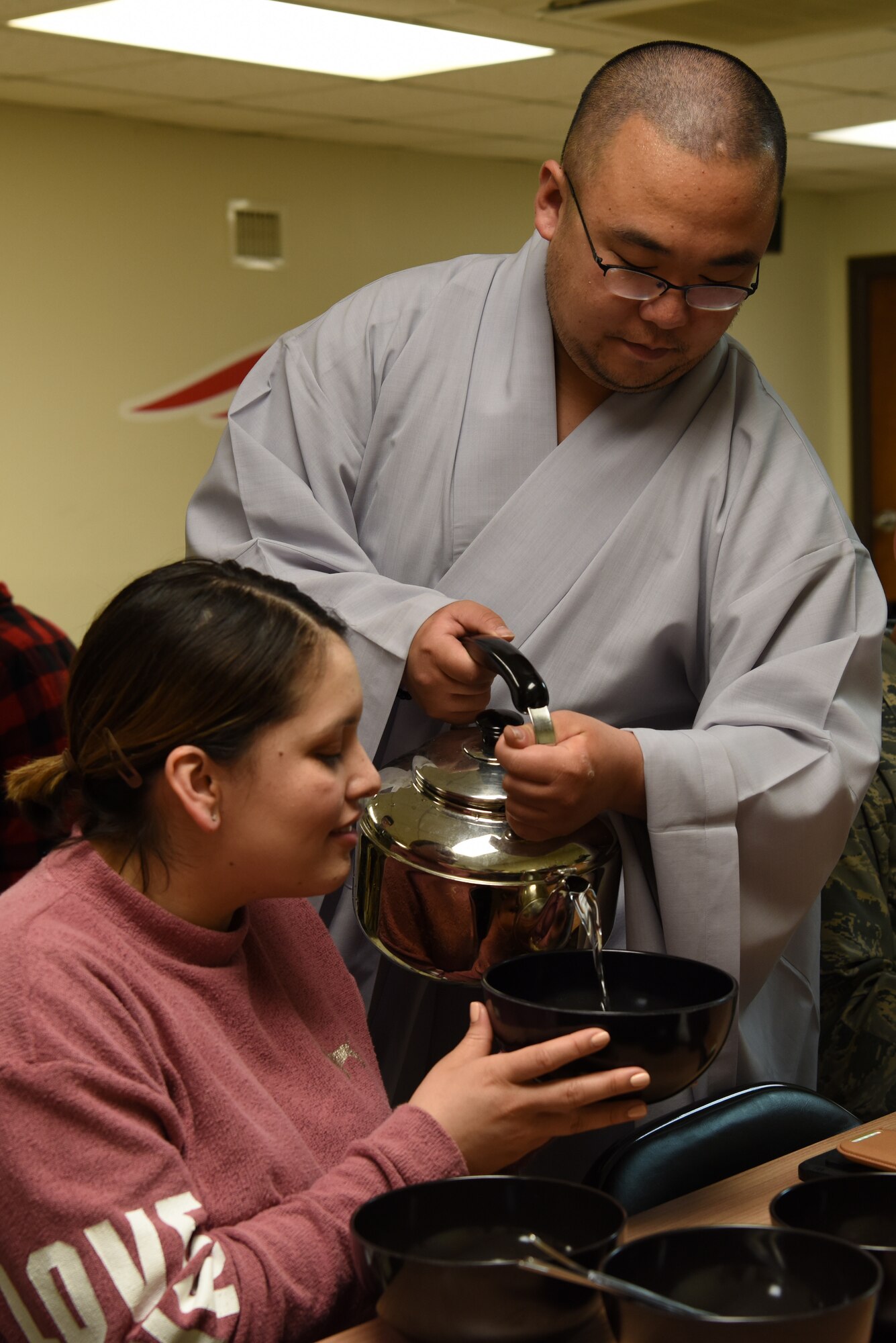 Republic of Korea Air Force Capt. Sungcheol Lee, 38th Fighter Group chaplain, pours water into a bowl for U.S. Air Force Tech Sgt. Diane Balmer, 8th Force Support Squadron manpower analyst, during a Buddhist immersion course at Kunsan Air Base, Republic of Korea, April 11, 2019. Balmer used the water to clean bowls and utensils prior to a traditional Buddhist meal. (U.S. Air Force photo by Staff Sgt. Joshua Edwards)