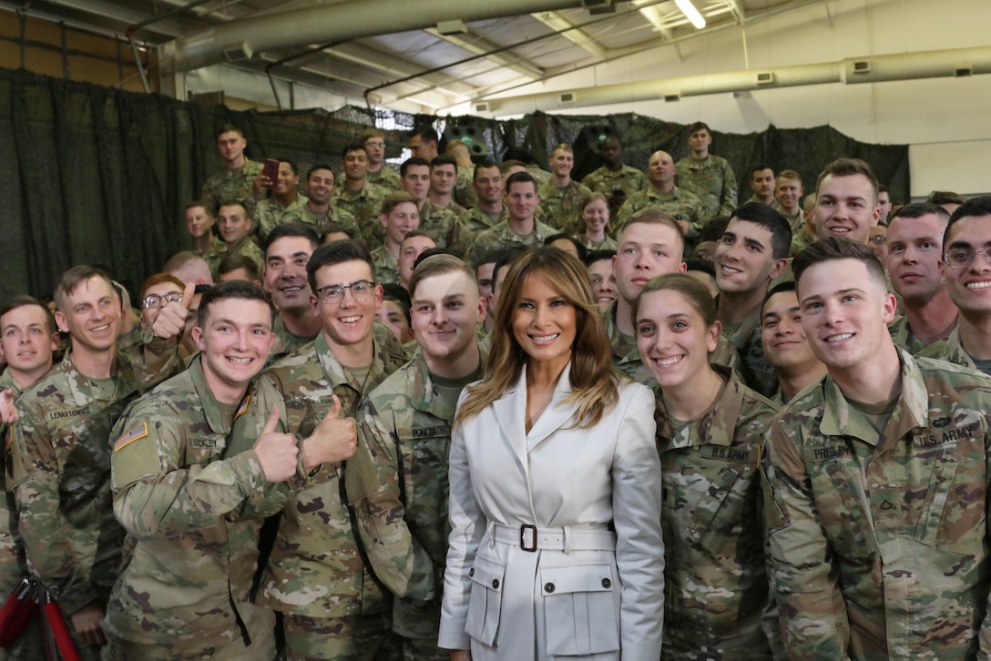 First Lady Melania Trump poses for a picture with a group of soldiers.
